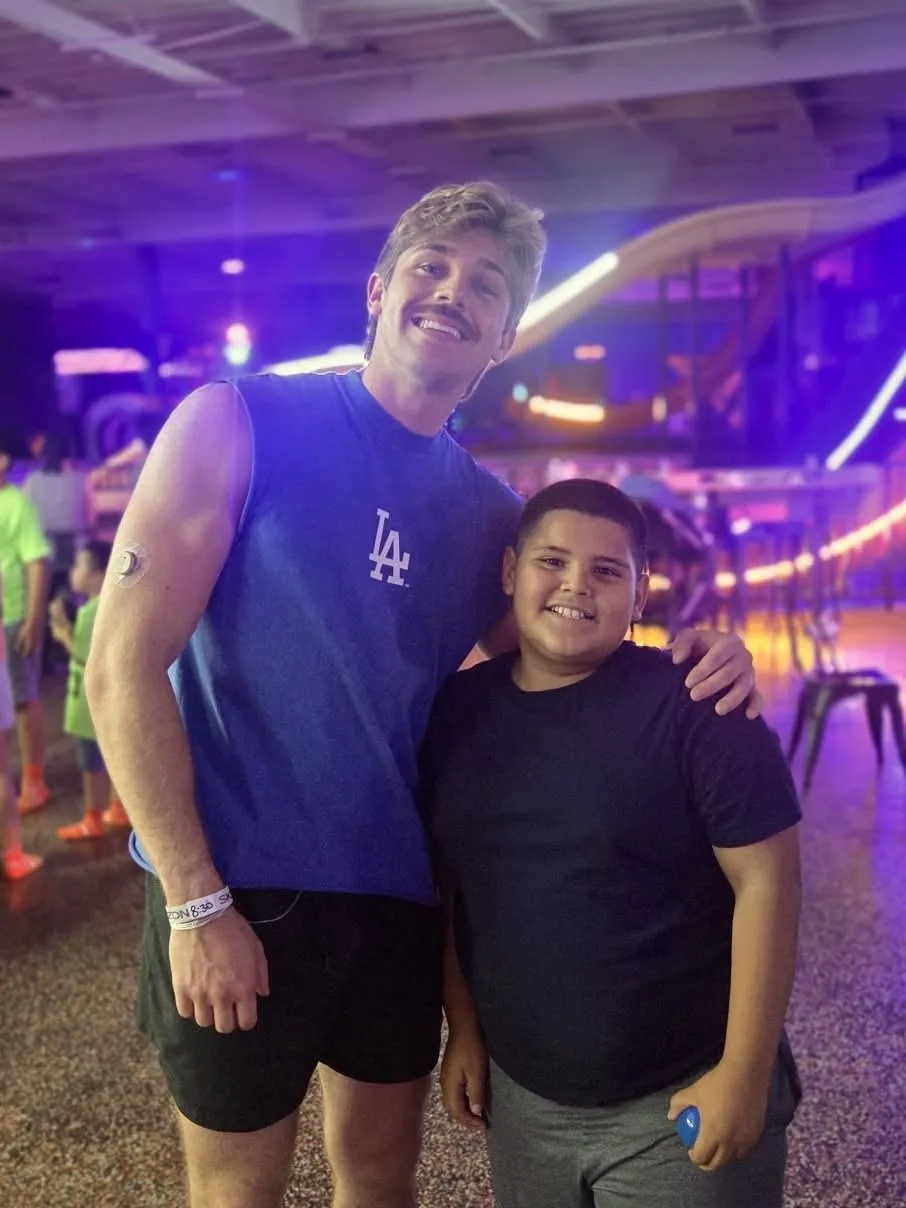 A mentor and his mentee at a glow arcade