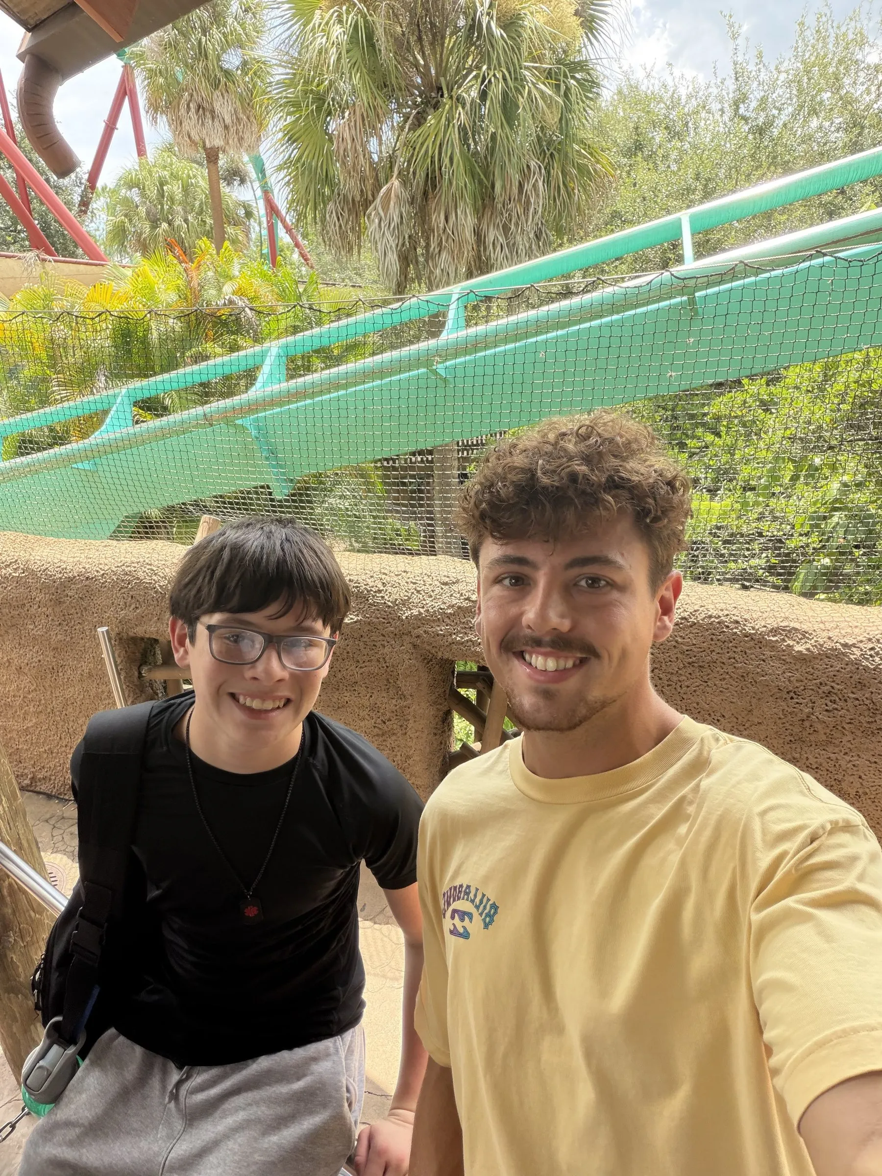A braveONE mentor and his mentee taking a selfie at a theme park