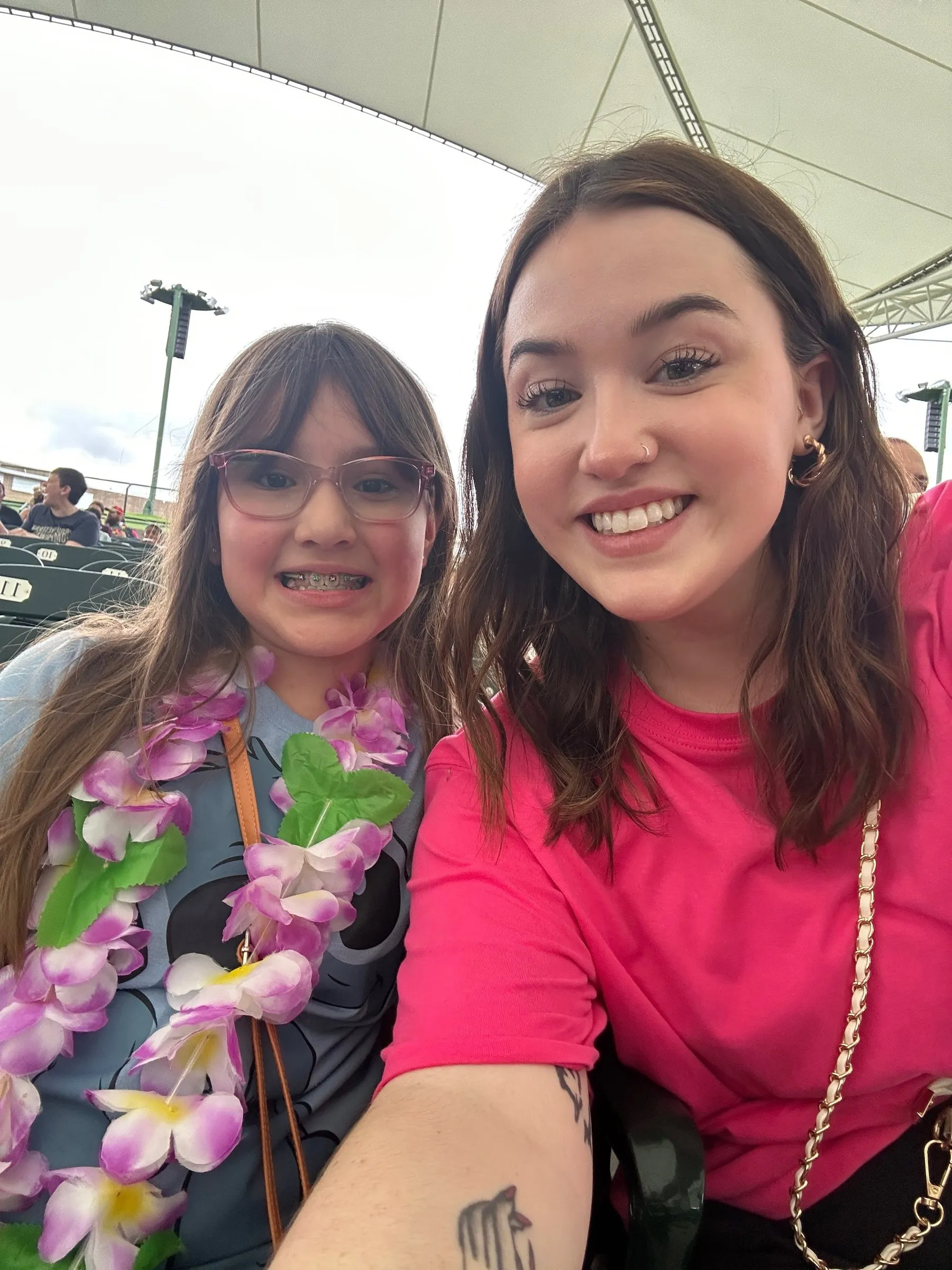 A mentee in a flower lei taking a selfie with her mentor