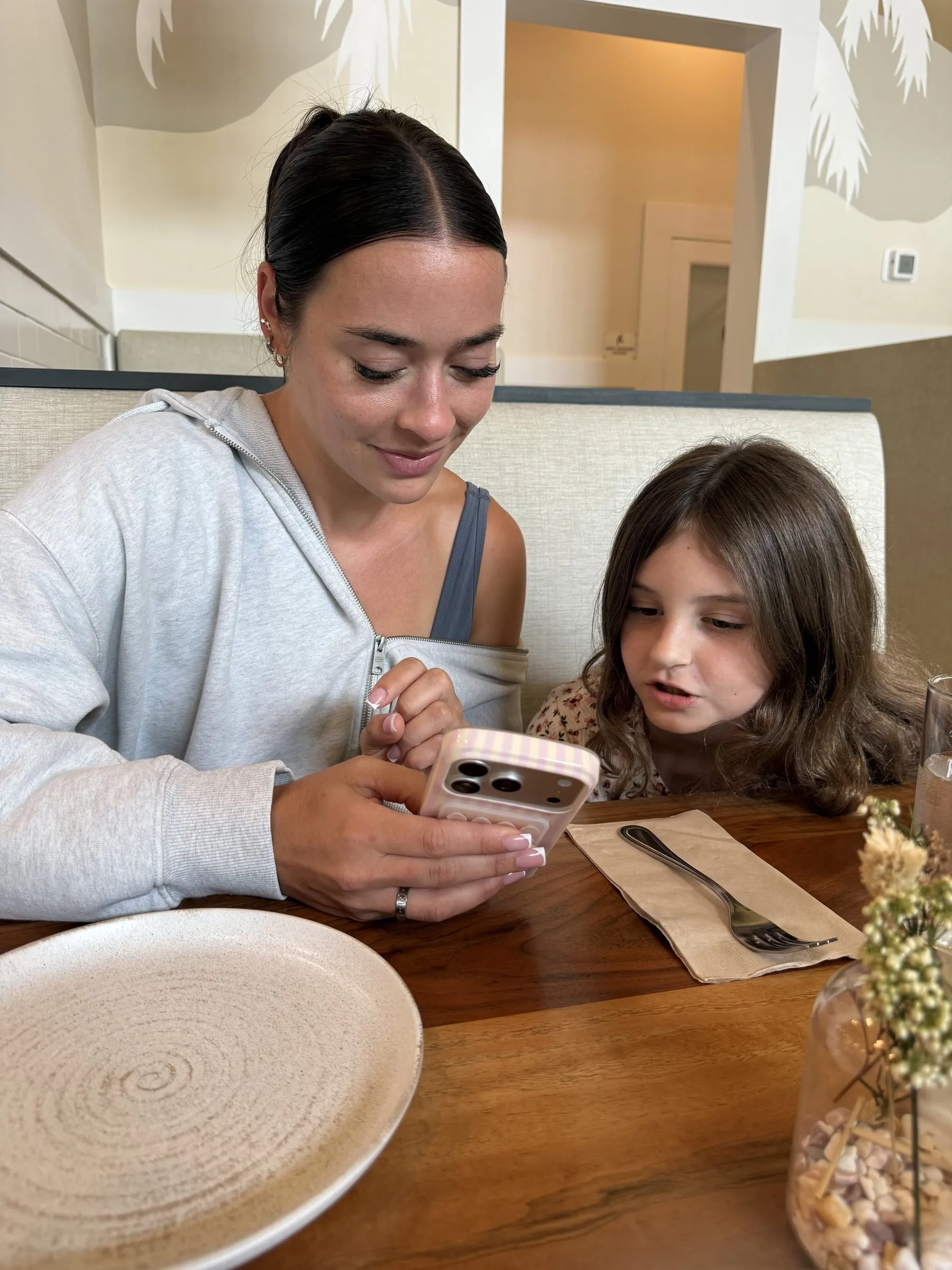 A mentor and mentee looking at a phone together over lunch