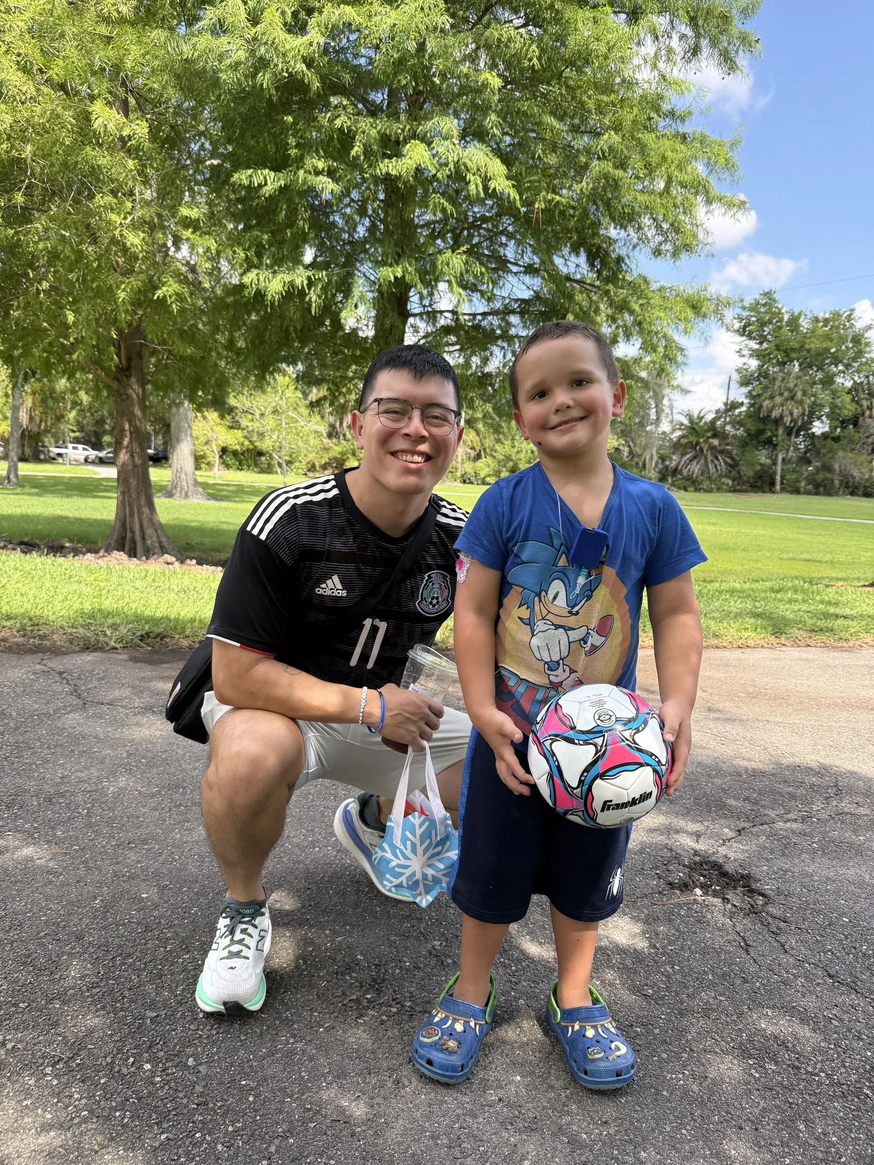 A mentor and his mentee with a soccer ball at the park