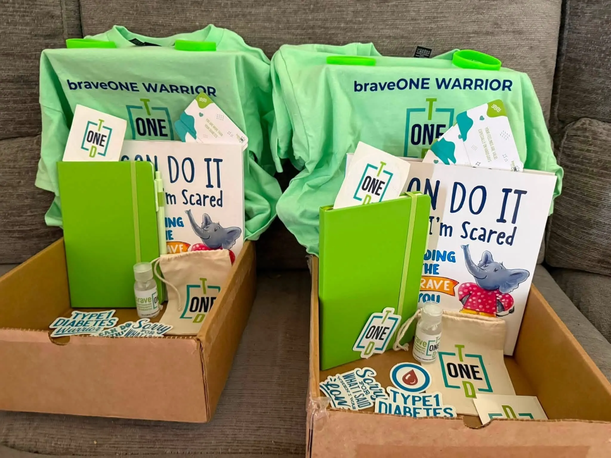 Two braveONE Welcome Warrior Boxes packed with t-shirts, journals and goodies